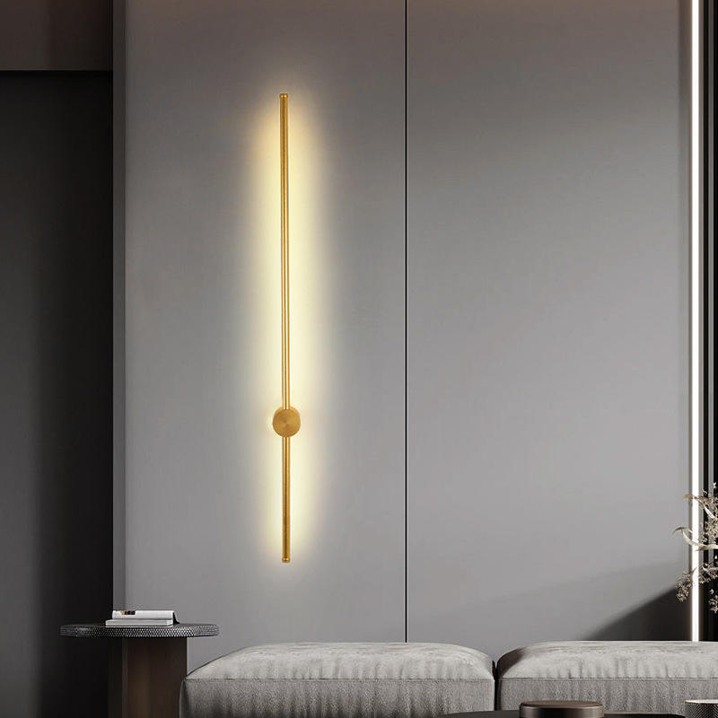 Applique murale LED dorée à tige verticale design épuré au dessus d'un canapé